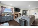 Bright living room with a cozy fireplace, decorative shelving, and dark hardwood floors at 15800 E 121St Ave # 4K, Brighton, CO 80603
