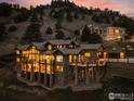 Expansive mountain home with stone accents and multiple balconies, illuminated at twilight at 166 Valley View Way, Boulder, CO 80304