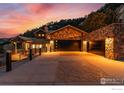 Stone-clad home features a spacious driveway leading to a large two car garage at 166 Valley View Way, Boulder, CO 80304