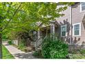 Attractive townhome exterior with a quaint front porch, complemented by well-maintained landscaping and a paved sidewalk at 1675 Saratoga Dr, Lafayette, CO 80026