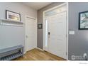 Bright foyer featuring hardwood floors, a coat rack, and a view of the front door at 1675 Saratoga Dr, Lafayette, CO 80026