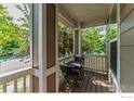 Front porch sitting area with a table and chairs and overhead string lights at 1675 Saratoga Dr, Lafayette, CO 80026