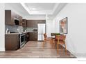 Modern kitchen with stainless steel appliances, dark cabinetry, and an adjacent dining area at 1707 Walnut St # 101, Boulder, CO 80302