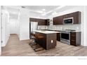 Modern kitchen with stainless steel appliances, an island with seating, and pendant lighting at 1707 Walnut St # 102, Boulder, CO 80302