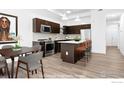 Modern eat-in kitchen features stainless steel appliances, dark cabinetry, and an island with bar seating at 1707 Walnut St # 203, Boulder, CO 80302