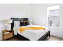 Well-lit bedroom features a bed with stylish linens, bedside tables, and a large window at 1707 Walnut St # 205, Boulder, CO 80302