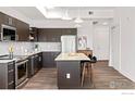 Modern kitchen with stainless steel appliances, dark cabinets, kitchen island, and pendant lighting at 1707 Walnut St # 205, Boulder, CO 80302