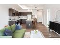 Open concept living room and kitchen featuring stainless steel appliances and a kitchen island with bar stools at 1707 Walnut St # 205, Boulder, CO 80302