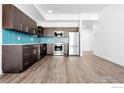 Modern kitchen features stainless steel appliances, dark cabinets, wood floors, and a blue backsplash at 1707 Walnut St # 301, Boulder, CO 80302