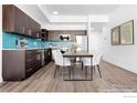 Stylish eat-in kitchen featuring stainless steel appliances, dark cabinetry, and a vibrant blue backsplash at 1707 Walnut St # 301, Boulder, CO 80302