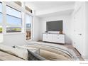 Bright bedroom with large windows offering mountain views, a sleek dresser, and a comfortable bed at 1707 Walnut St # 305, Boulder, CO 80302