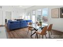 Open concept living space including a glass dining table with leather chairs, and a living area with a blue sectional at 1707 Walnut St # 307, Boulder, CO 80302