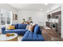 Open-concept living area featuring a stylish blue sectional sofa connecting to a modern kitchen with stainless steel appliances at 1707 Walnut St # 307, Boulder, CO 80302