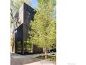 Modern architecture featuring a dark wood exterior, large windows, and mature trees at 1838 22Nd St, Boulder, CO 80302