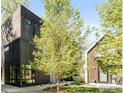 A modern townhome with dark wood siding, large windows, and a professionally landscaped yard at 1838 22Nd St, Boulder, CO 80302