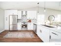 Bright kitchen with stainless steel appliances, modern backsplash, and white cabinetry at 1920 Donovan Dr, Longmont, CO 80501