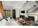 Bright living room with stone fireplace, balcony access, and hardwood floors at 20 S Boulder Cir # 2312, Boulder, CO 80303