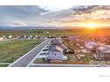 Sunset view of homes in a new community with expansive scenic views at 2161 Gelbvieh St, Mead, CO 80542