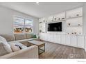 Cozy living room with large sectional couch, decorative shelving, and flat screen TV at 2161 Gelbvieh St, Mead, CO 80542
