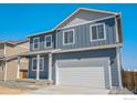 Charming two-story home featuring a two-car garage, covered porch, and a modern blue exterior at 2212 Crosswind St, Fort Lupton, CO 80621