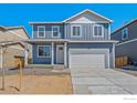 Charming two-story home featuring a two-car garage, covered porch, and a modern blue exterior at 2212 Crosswind St, Fort Lupton, CO 80621