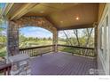 Covered deck features stone archway and outdoor view of the golf course at 2222 Tamarron Ln, Lafayette, CO 80026