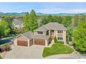 Beautiful two-story home featuring a large garage, stone accents, and well-manicured lawn at 2222 Tamarron Ln, Lafayette, CO 80026
