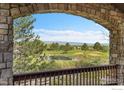 Stone archway framing the picturesque view of the golf course and pond at 2222 Tamarron Ln, Lafayette, CO 80026