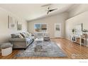 Bright living room featuring vaulted ceilings, hardwood floors, a ceiling fan, and a window view at 2354 Billings Ln, Longmont, CO 80504
