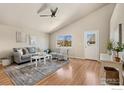 Bright living room featuring vaulted ceilings, hardwood floors, and large window views at 2354 Billings Ln, Longmont, CO 80504