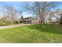 Two-story home with well-manicured lawn, mature trees, and an attached two car garage at 2548 Horseshoe Cir, Longmont, CO 80504
