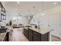 Modern kitchen with stainless steel appliances, an island with granite countertops, and an open layout connecting to the living space at 2743 Bear Springs Cir, Longmont, CO 80503