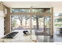 Modern kitchen with a stone island and gas range, seamlessly blending into the outdoor dining area at 2848 S Lakeridge Trl, Boulder, CO 80302