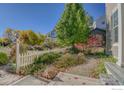 Landscaped front yard featuring a walking path and mature landscaping with a variety of trees and bushes at 3002 Shoshone Trl, Lafayette, CO 80026