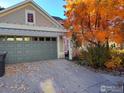 Spacious two-car garage with a pergola and a driveway covered in autumn leaves at 3002 Shoshone Trl, Lafayette, CO 80026