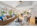 Bright living room featuring hardwood floors, large windows, and a neutral color palette, seamlessly flowing into the kitchen at 4059 Nevis St, Boulder, CO 80301