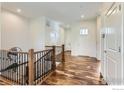 Bright foyer with hardwood floors, white walls, and an open staircase at 4419 Maxwell Ave, Longmont, CO 80503