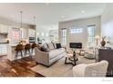 Open-concept living room with hardwood floors, lots of windows, and modern decor at 4419 Maxwell Ave, Longmont, CO 80503