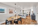 Open-concept dining area with a wooden table and bar seating, seamlessly flowing into the modern kitchen at 4511 Bryant St, Denver, CO 80211