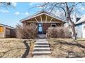 Charming brick home with a peaked roof, manicured shrubs, and a concrete walkway leading to the front door at 4511 Bryant St, Denver, CO 80211