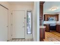 The foyer leads to the kitchen with updated appliances, white door, and hardwood floors at 4619 Chestnut Ln, Boulder, CO 80301