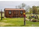 Cozy shed with charming details like flower boxes, firewood, and vintage decor at 6310 W County Road 4, Berthoud, CO 80513