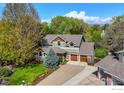 Overhead shot of a beautiful home featuring a well-manicured lawn, mature trees, and a welcoming two-car garage at 7905 Wellshire Ct, Niwot, CO 80503