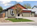 Charming exterior with a three-car garage, stone accents, and a manicured front yard at 9137 Harlequin Cir, Longmont, CO 80504