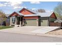 Charming home boasts a three-car garage, unique orange accents, and a well-manicured lawn at 9137 Harlequin Cir, Longmont, CO 80504