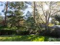 Secluded backyard showcasing beautiful landscaping with mature trees and a well-maintained lawn at 11845 W 73Rd Dr, Arvada, CO 80005
