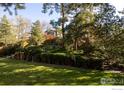 Lush backyard featuring multilevel landscaping with stone steps and mature trees at 11845 W 73Rd Dr, Arvada, CO 80005