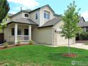 Charming home featuring a covered porch and a well-manicured front yard at 1204 Ptarmigan Dr, Longmont, CO 80504