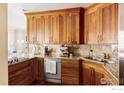 Modern kitchen with wood cabinetry, stainless steel appliances, and granite countertops at 1301 Canyon Blvd # 207, Boulder, CO 80302