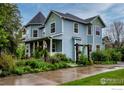 Charming two-story home with blue siding, a welcoming front porch, and a beautifully landscaped yard at 1369 Padfield Pl, Erie, CO 80516